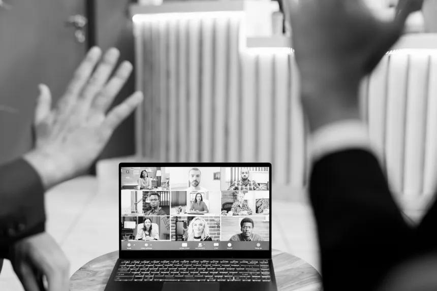 virtual conference call with hands waving to laptop screen